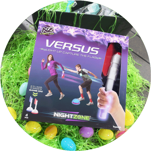 The packaged game of Capture the Flag light up version, surrounded by green easter grass and colorful easter eggs.